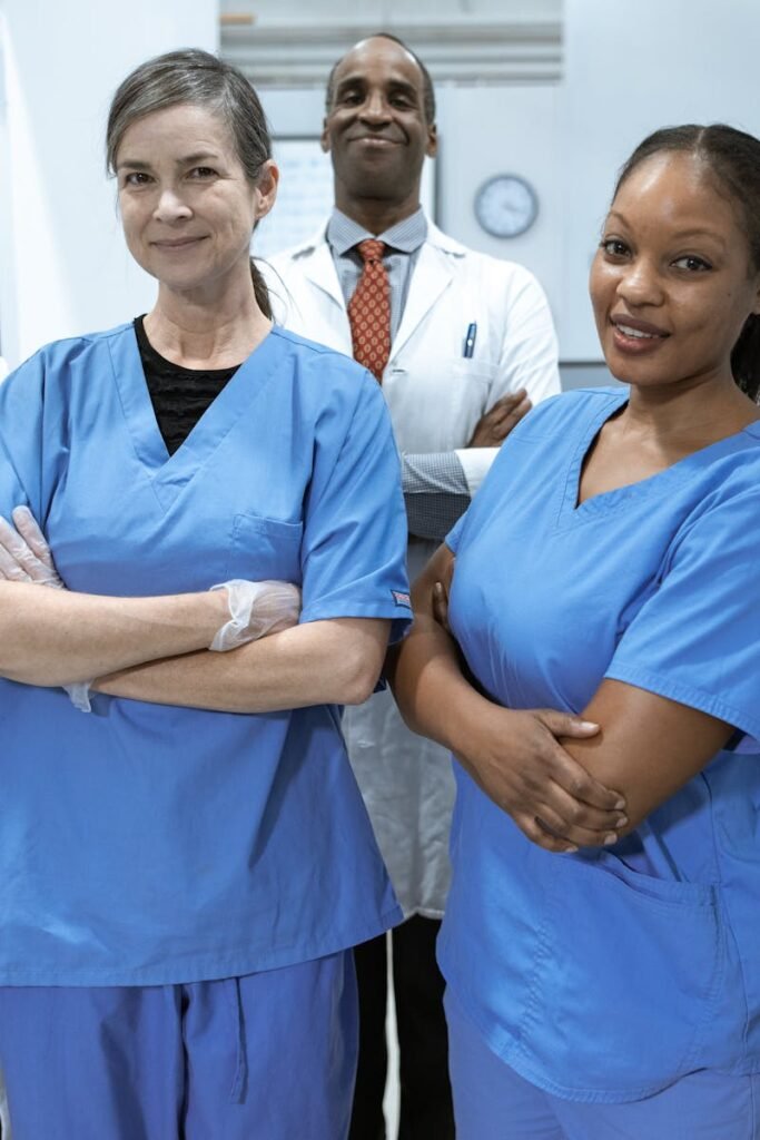 A diverse team of doctors and nurses smiling confidently in a hospital setting.
